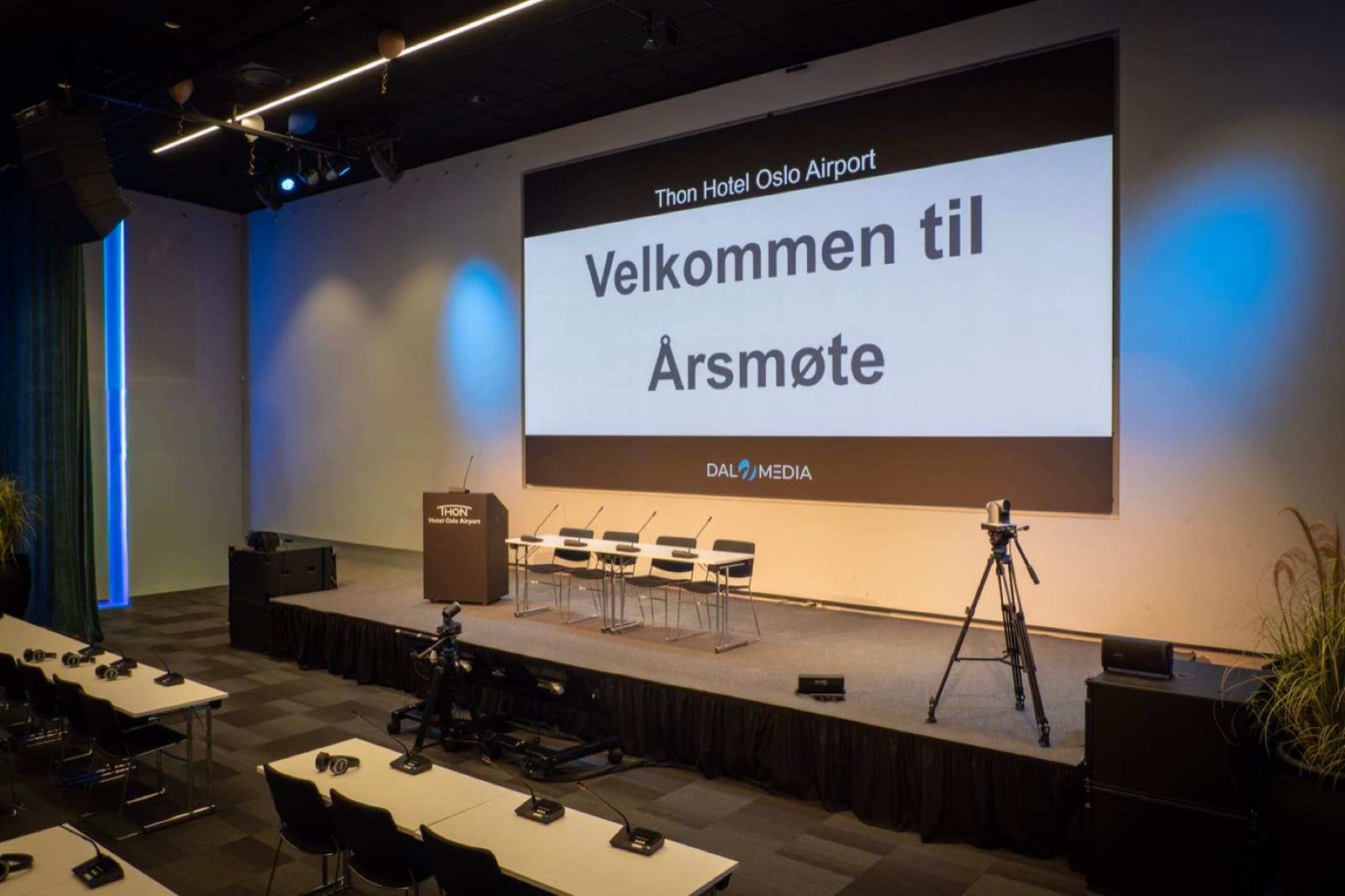 Scene rigget med storskjerm, talerstol, panelbord og kameraer
